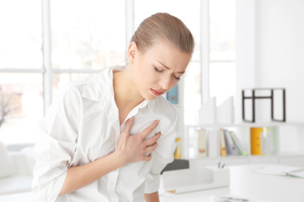 Woman holding her chest in discomfort